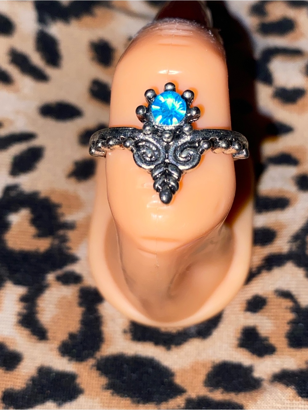 Blue crystal ring with ornate silver filigree design